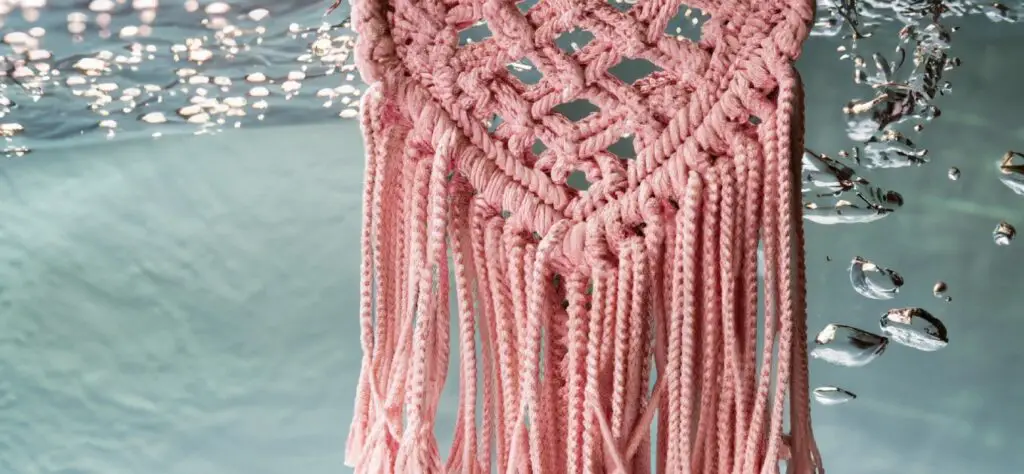 Pink macrame wall hanging submerged in water